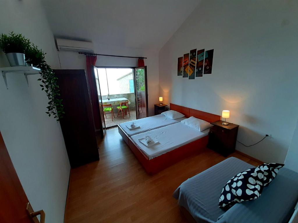 mały pokój z 2 łóżkami i stołem w obiekcie Apartmani Toni - Apartman Maslina w Hvarze