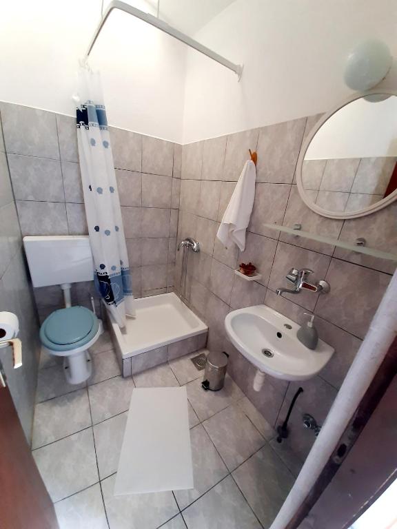 łazienka z umywalką, toaletą i lustrem w obiekcie Apartmani Toni - Apartman Maslina w Hvarze