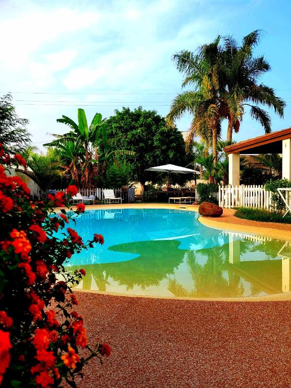 a swimming pool in a yard with trees and flowers at Dependance Oscar in Carrozziere