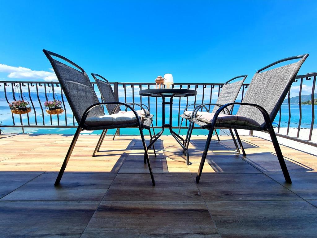 a table and chairs sitting on a deck overlooking the water at Apartmani Rustik Trpejca in Trpejca