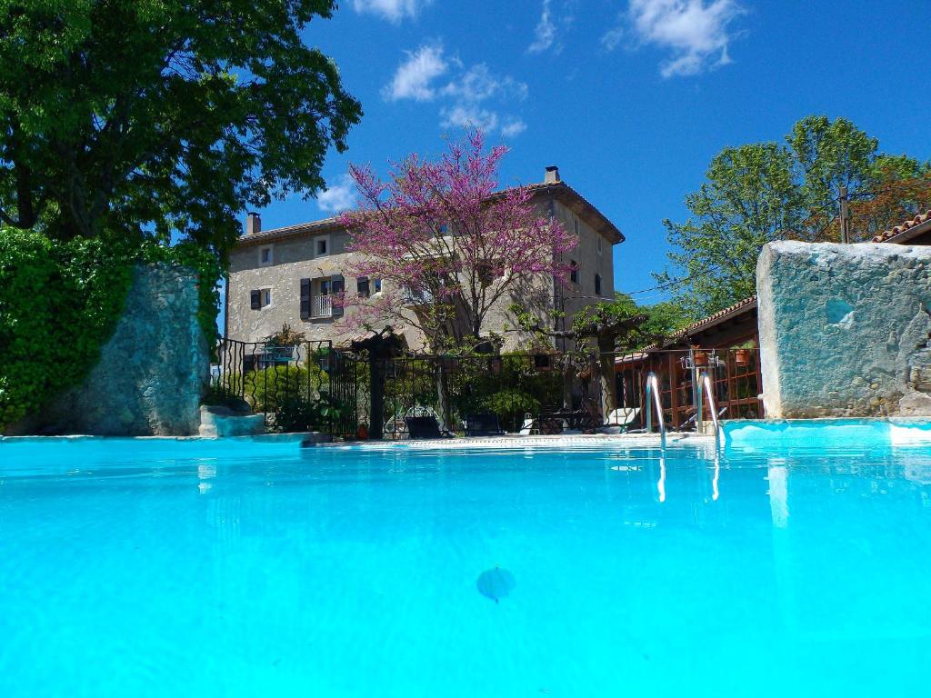 a large pool of blue water in front of a building at Logis des Magnans -Les terrasses du Coutach - in Sauve