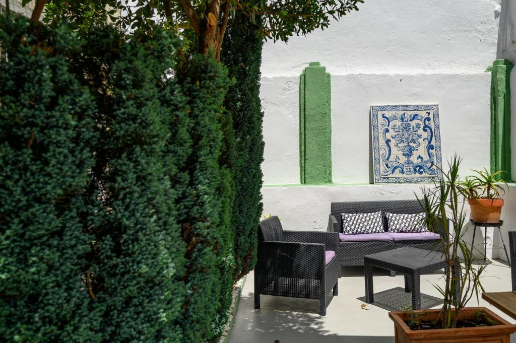 um pátio com um banco ao lado de uma sebe verde em Terrace Lisbon Hostel em Lisboa