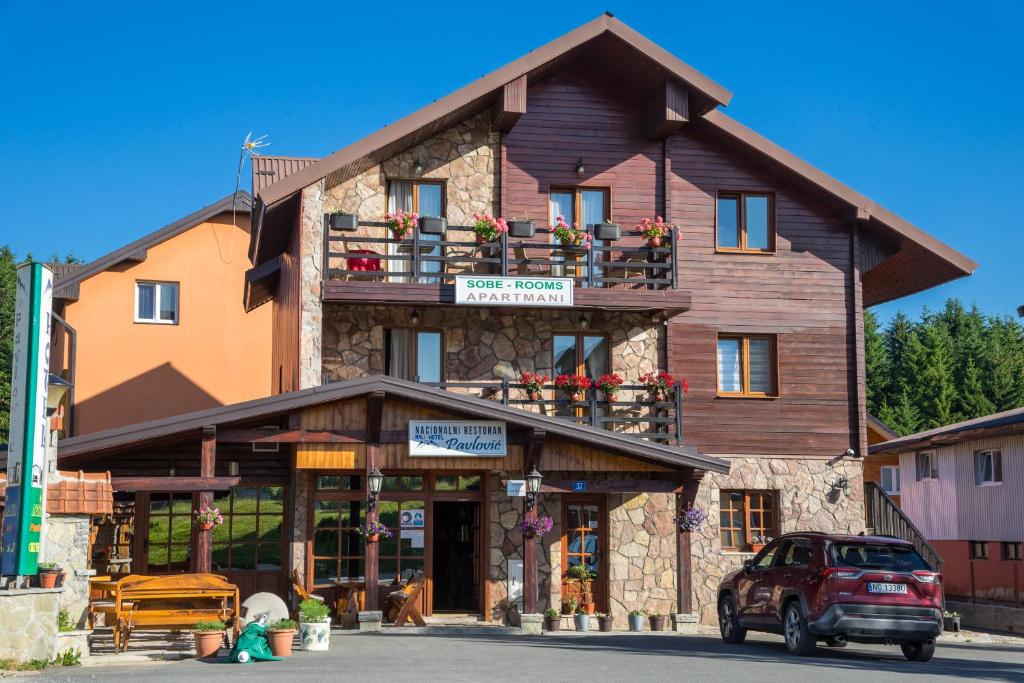 un gran edificio de madera con un balcón en la parte superior. en Hotel Pavlović en Žabljak