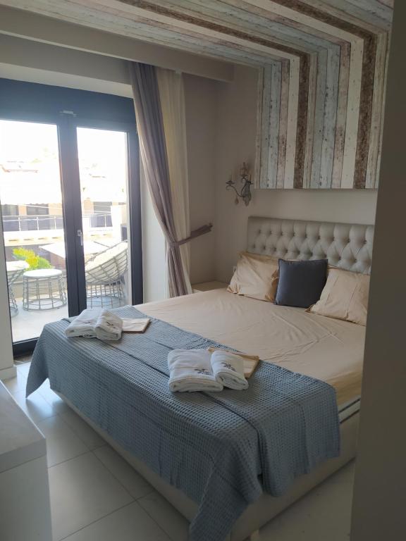 a bedroom with a large bed with towels on it at Colibri Luxury Apartments in Hanioti