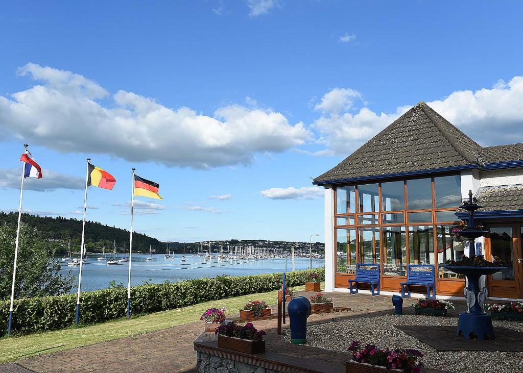 un bâtiment avec deux drapeaux et un kiosque dans l'établissement Whispering Pines, à Crosshaven