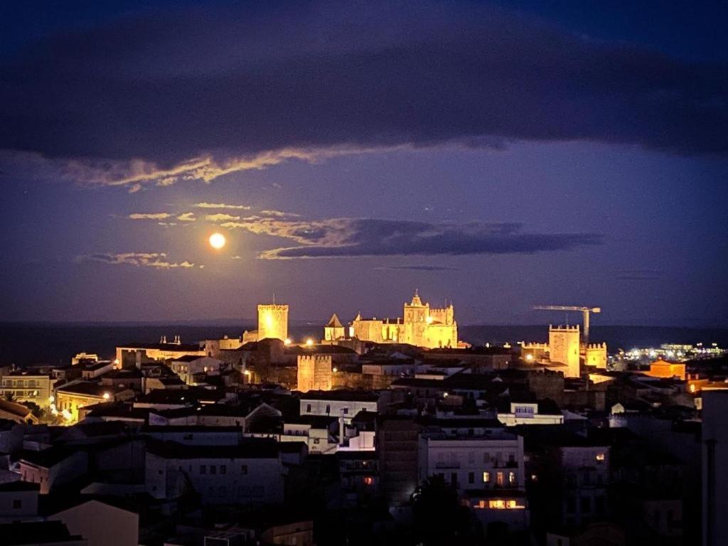 een uitzicht op een stad 's nachts met de maan bij EL CIELO DE CÁCERES in Cáceres