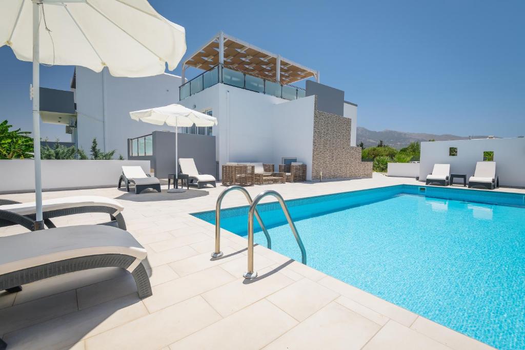 a swimming pool with chairs and an umbrella on a building at ASTERIA PEARL VILLA 2 with Rooftop Jacuzzi in Tigaki