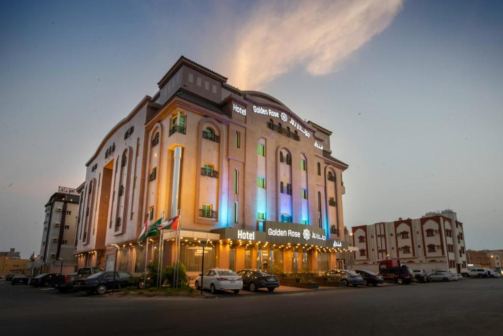 a large building with cars parked in front of it at Golden Rose Hotel in Jazan