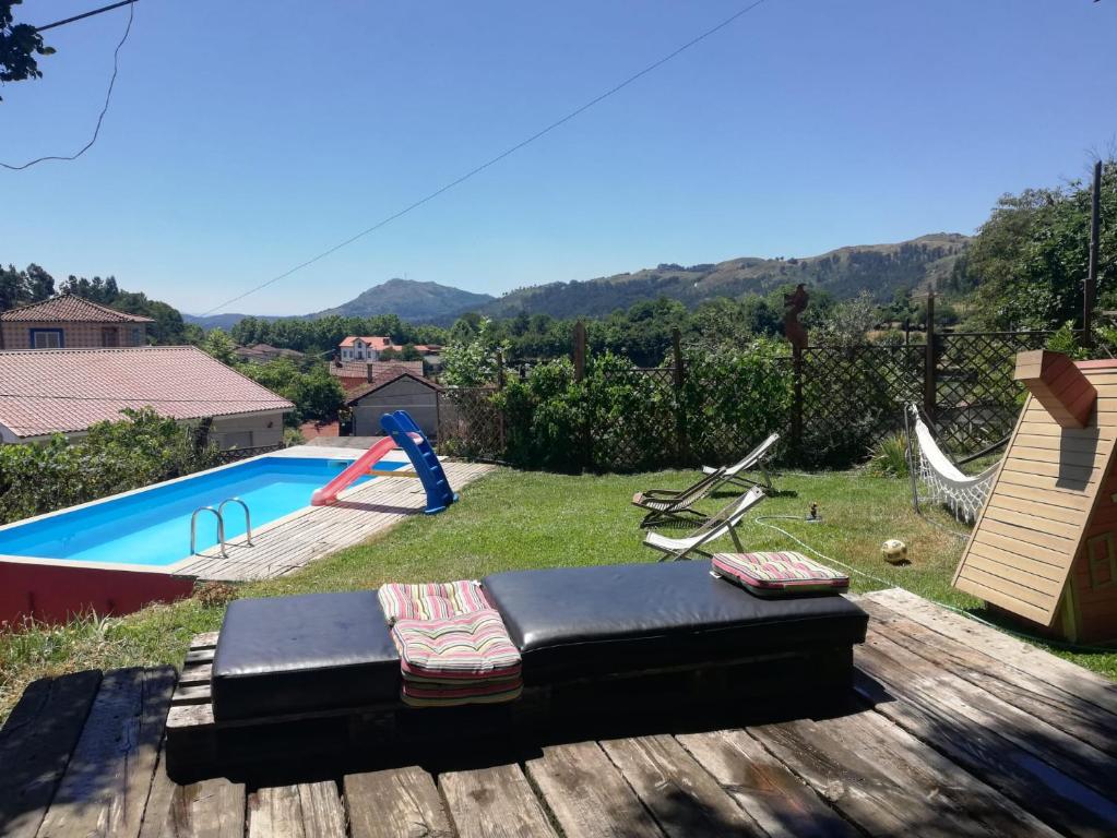 a view of a backyard with a pool and swings at Casa S. Nicolau in Cabeceiras de Basto
