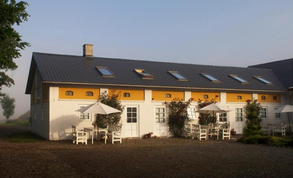 un gran edificio blanco con mesas y sillas en Nymarksminde, en Vodskov