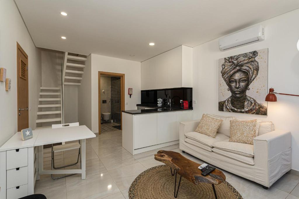 ein Wohnzimmer mit einem Sofa und einem Tisch in der Unterkunft Casa da Praca - City Center - Faro in Faro