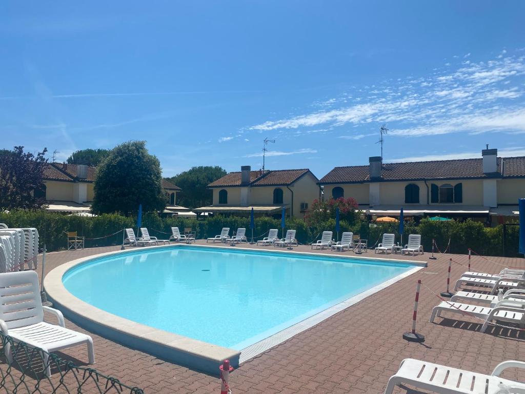 einen großen Pool mit Liegestühlen in der Unterkunft Villaggio Teodorico in Punta Marina