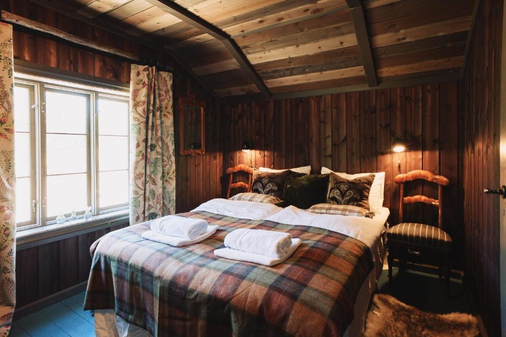 1 dormitorio con 1 cama con 2 toallas en Reinheimen Lodge en Skjåk