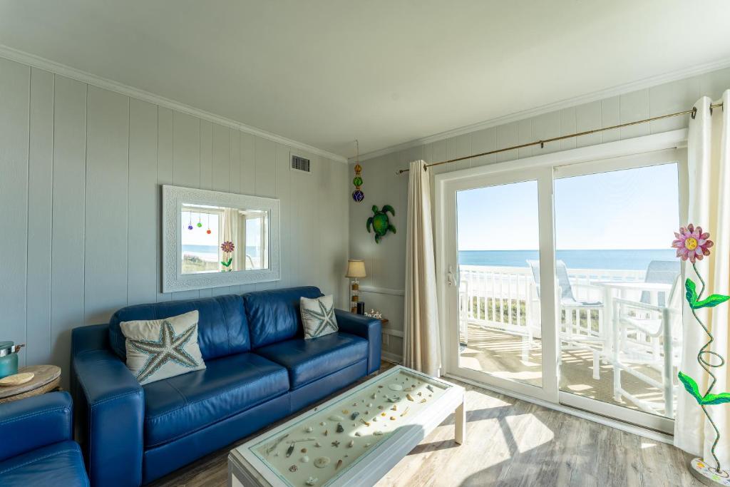 マートルビーチにあるCharming Ocean-view Condo at Ocean Pier 3の海の景色を望むリビングルーム(青いソファ付)