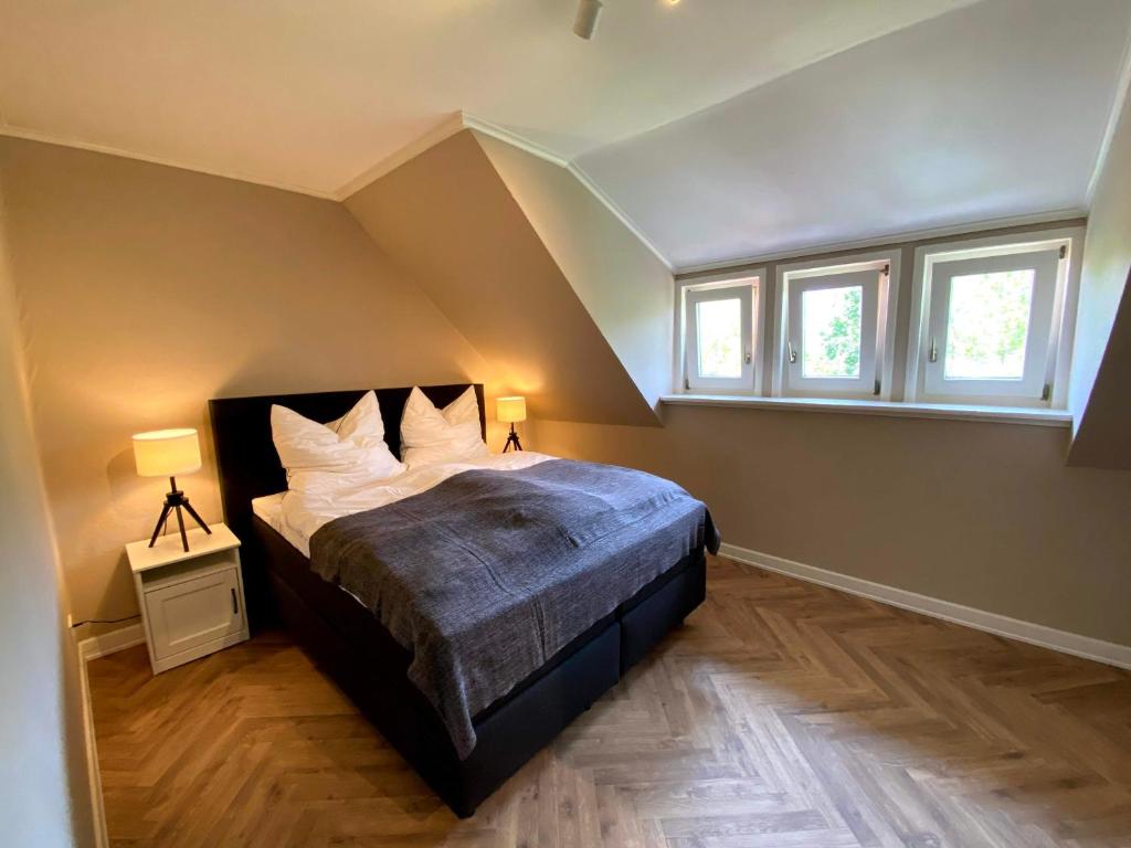 ein Schlafzimmer mit einem Bett und zwei Fenstern in der Unterkunft Ferienwohnung Gipfelstürmer in Bad Harzburg