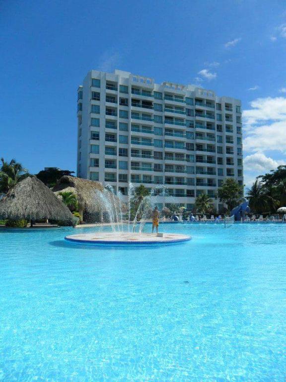 a fountain in the middle of the water in front of a building at Costazul Suites 705 in Santa Marta