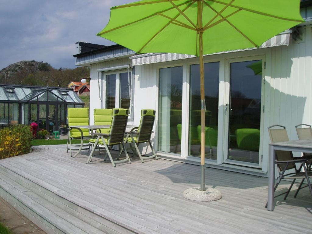 a patio with a table and chairs and an umbrella at Nösund Holiday Home in Nösund