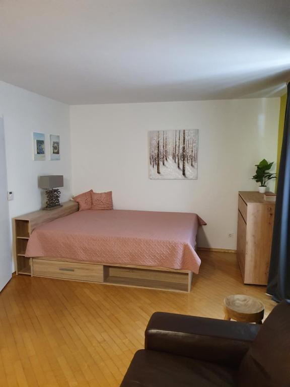 ein Schlafzimmer mit einem Bett und einem Sofa in der Unterkunft Apartma Kreda in Mojstrana