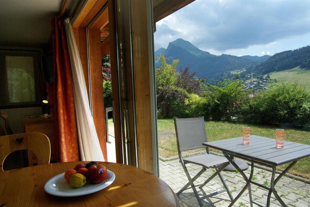 Appart Saint-Antoine Morzine vue soleil jardin calme parking 2 à 4 pers في مورزين: طاولة عليها صحن من الفاكهة أمام النافذة