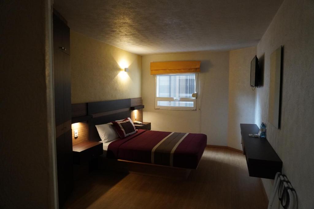 pokój hotelowy z łóżkiem i oknem w obiekcie Ibeurohotel Guadalajara Expo w mieście Guadalajara