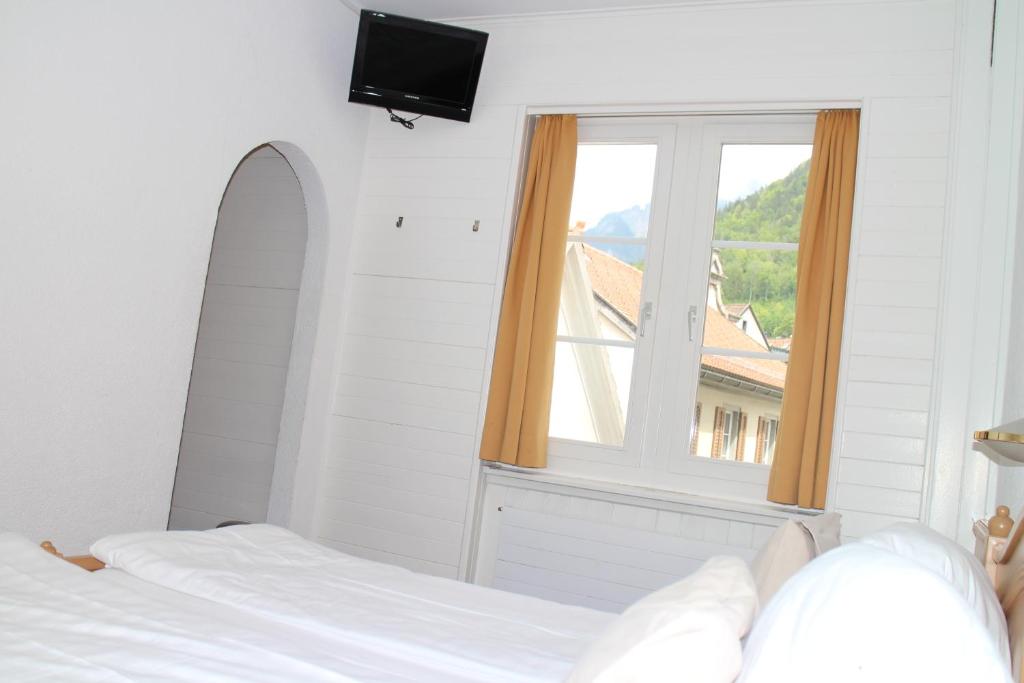 a bedroom with a bed and a window at Zunfthaus zur Rebleuten in Chur
