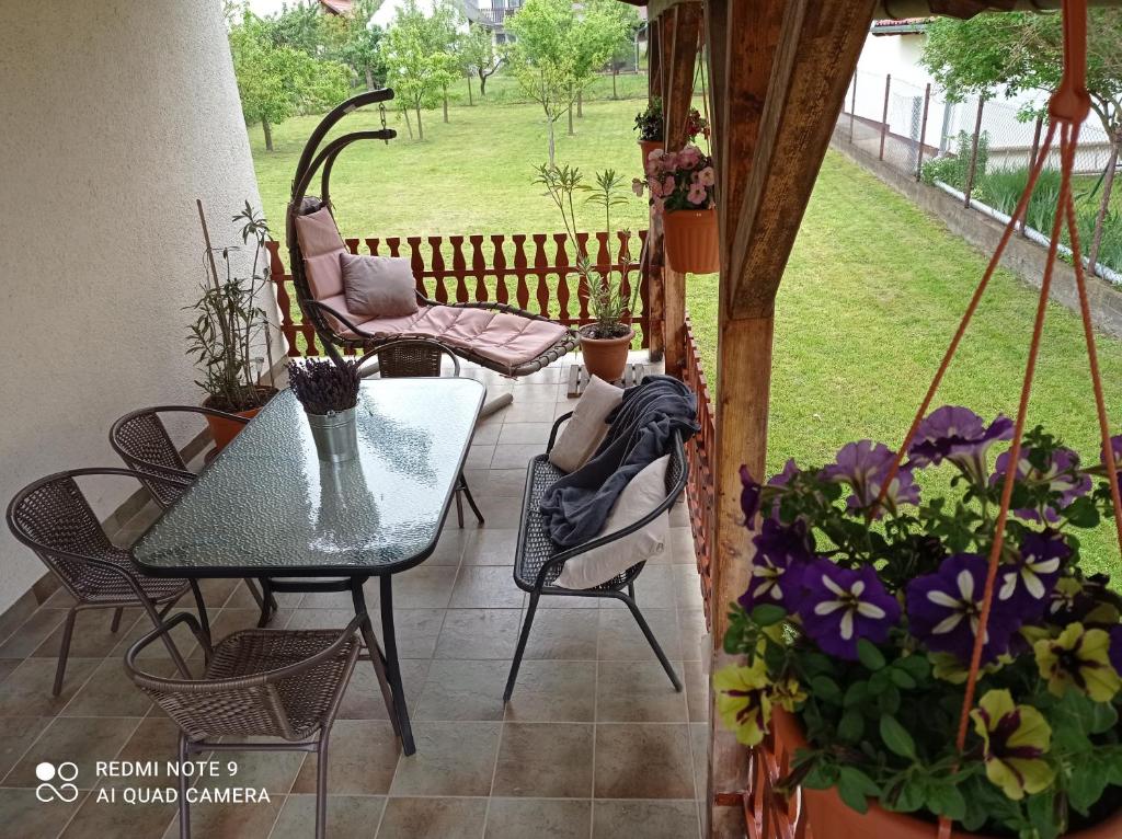 patio ze stołem, krzesłami i kwiatami w obiekcie Liget Fruit Garden w Zalakaros