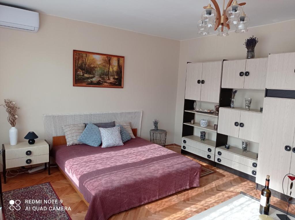 1 dormitorio con 1 cama y armarios blancos en Liget Fruit Garden, en Zalakaros