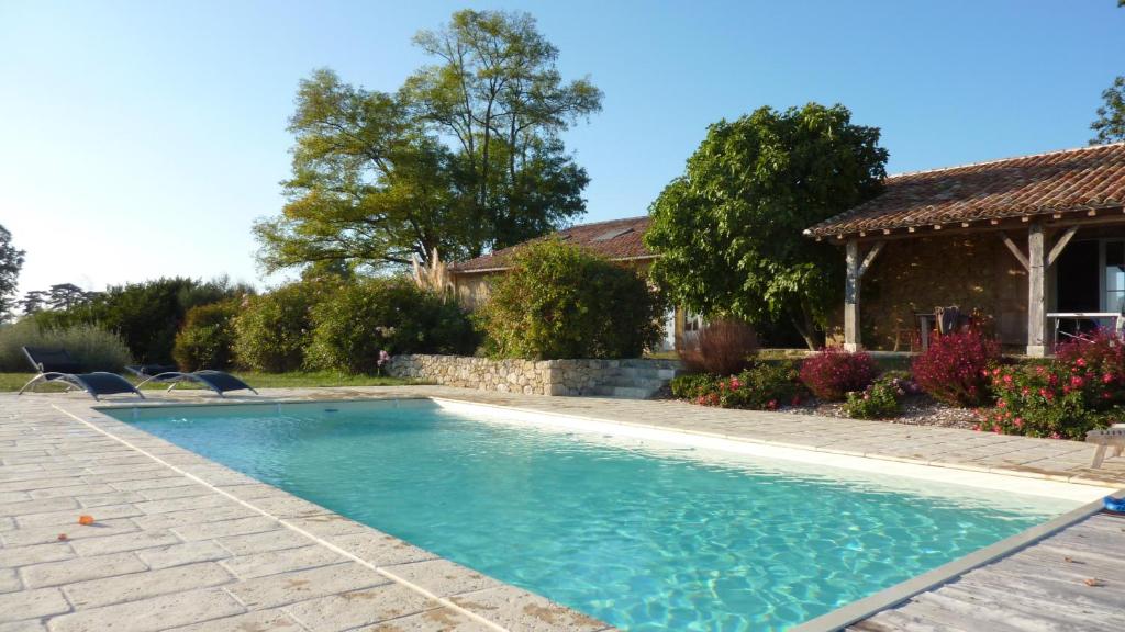 una piscina en un patio con una casa en Chambres d'Hôtes La Treille, en Ligardes