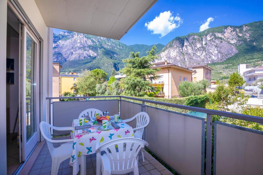 a balcony with a table and chairs with a view of mountains at Appartamento Aurora in Riva del Garda