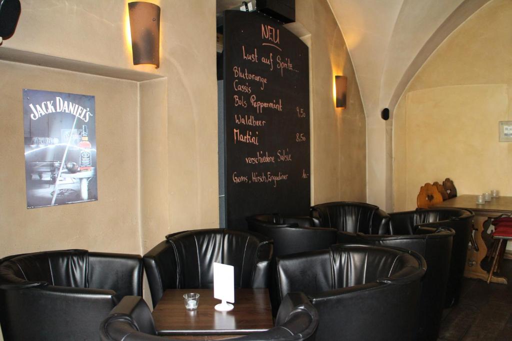 a dining room with black leather chairs and a chalkboard at Zunfthaus zur Rebleuten in Chur
