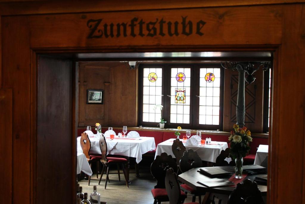 a restaurant with tables and chairs and stained glass windows at Zunfthaus zur Rebleuten in Chur