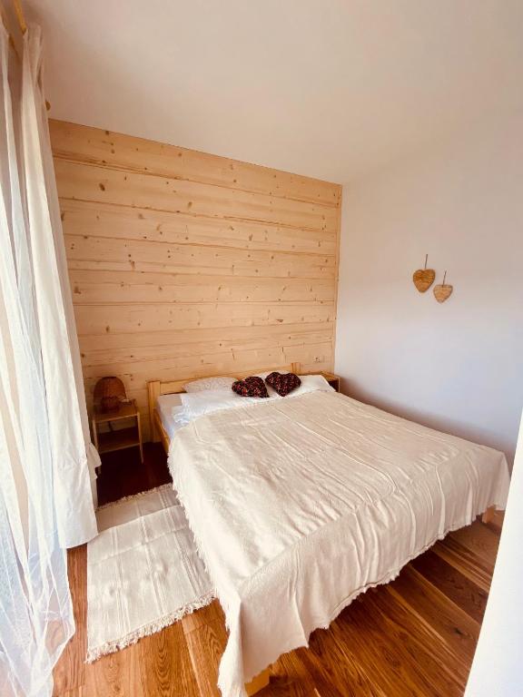 sypialnia z łóżkiem i drewnianą ścianą w obiekcie ROZTOKI Four Seasons w mieście Witów