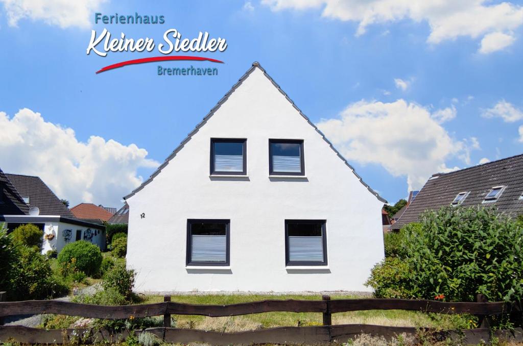 a white house with a triangular roof at Ferienhaus Kleiner Siedler in Bremerhaven