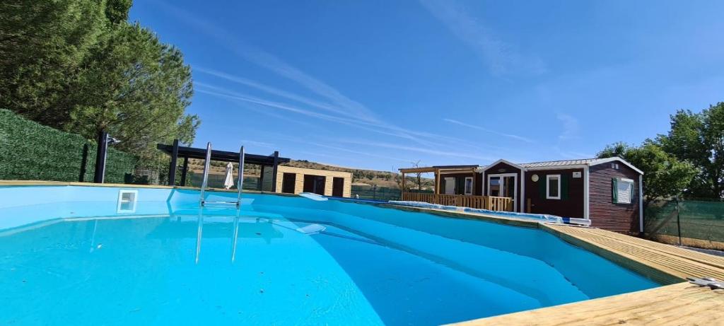 a swimming pool with a tiny house in the background at Cabañas las Rosas in Pollos