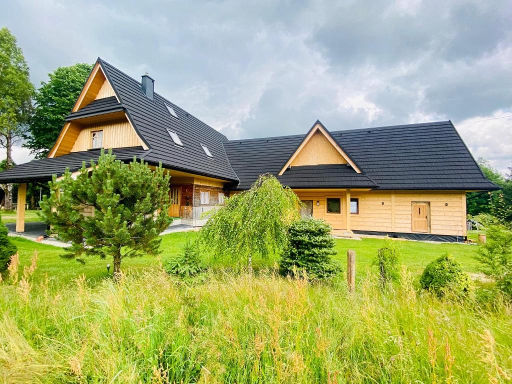 a large house with a black roof at ROZTOKI Four Seasons in Witów
