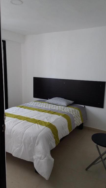 1 dormitorio con 1 cama grande y cabecero negro en Casa Zona Iteso, Expo, Plaza del Sol, 4 habitaciones 8 huespedes / compartida, en Guadalajara