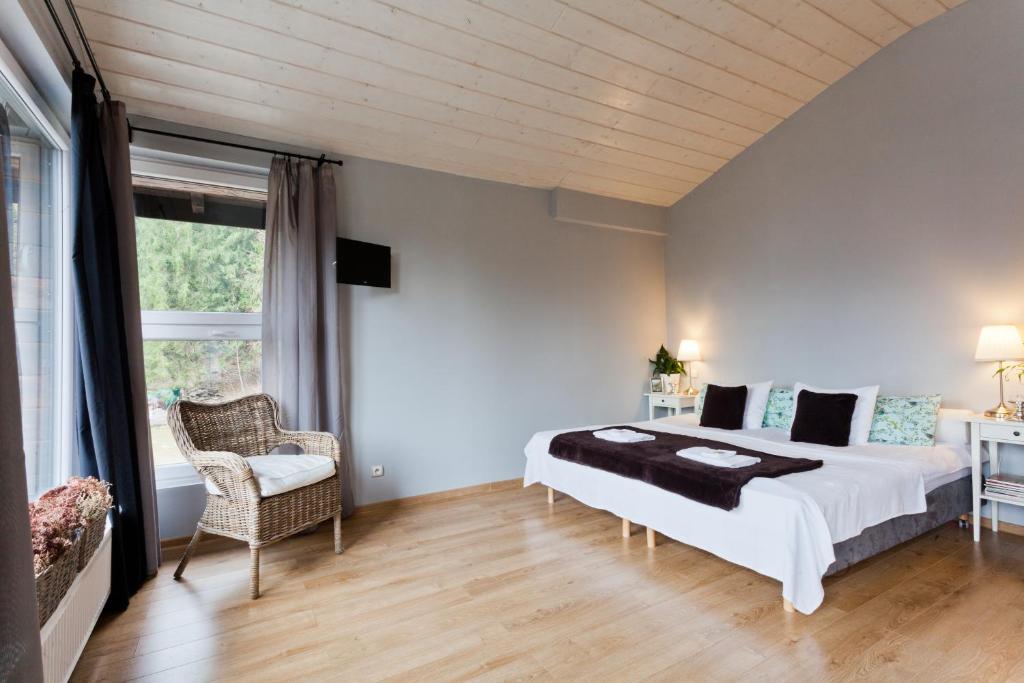 シュチルクにあるKarolinka Guest Houseのベッドルーム(大型ベッド1台、椅子付)