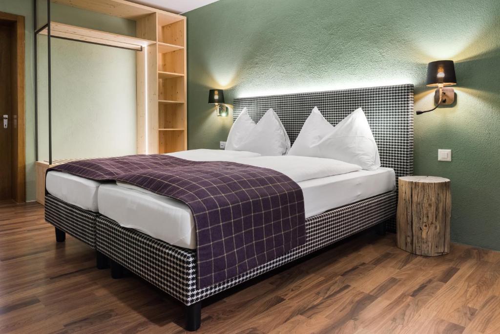 a bedroom with a large bed with a purple blanket at Hotel Bären in St. Moritz