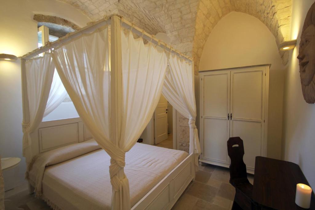 a bedroom with a canopy bed with a window at La Vecchia Tabaccheria B&B in Ostuni