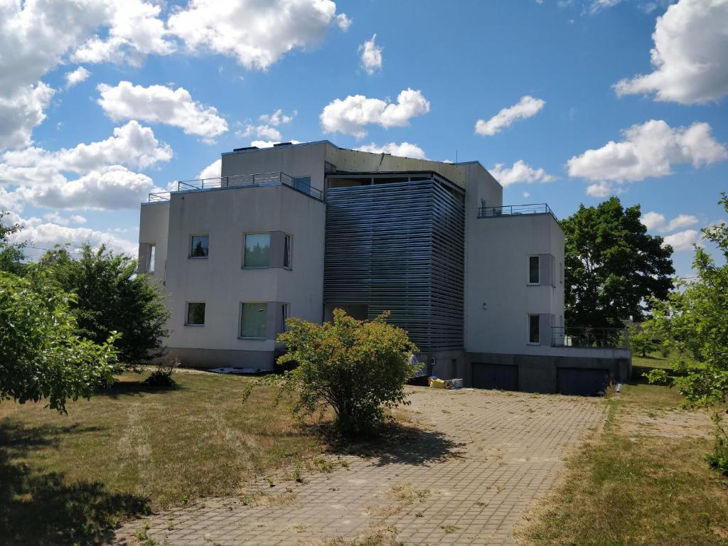 a building on top of a field with trees at Laheveere Villa in Värska