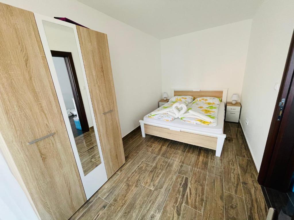 una piccola camera da letto con un letto e uno specchio di Apartmani Zivkovic Srebrno Jezero a Veliko Gradište