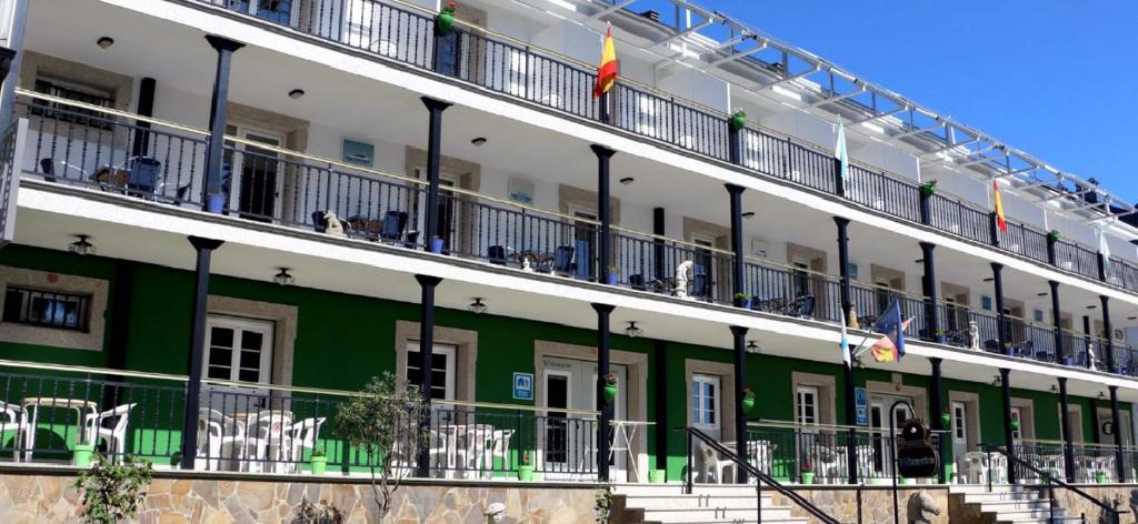 a large building with people on the balconies at Hotel Villa Jardín in Portomarin