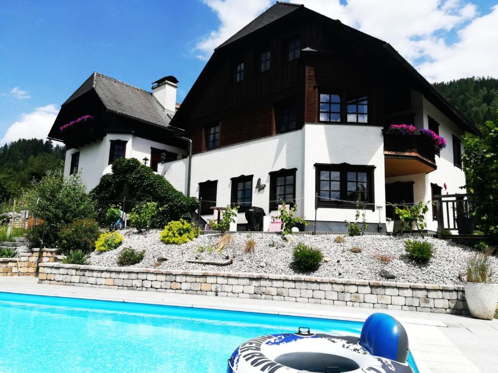 a house with a swimming pool in front of a house at Landhaus Seebacher in Spital am Pyhrn