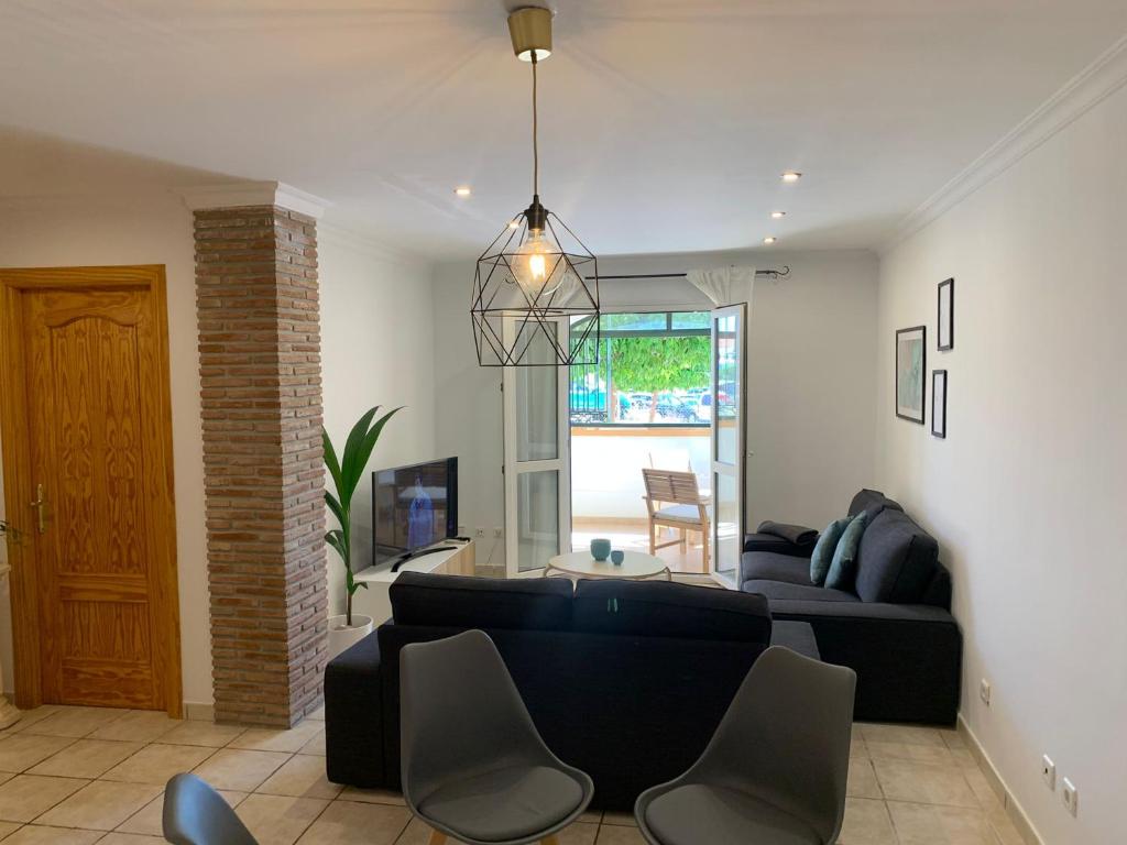 salon z czarną kanapą i krzesłami w obiekcie apartamento centrico silencioso w mieście Nerja