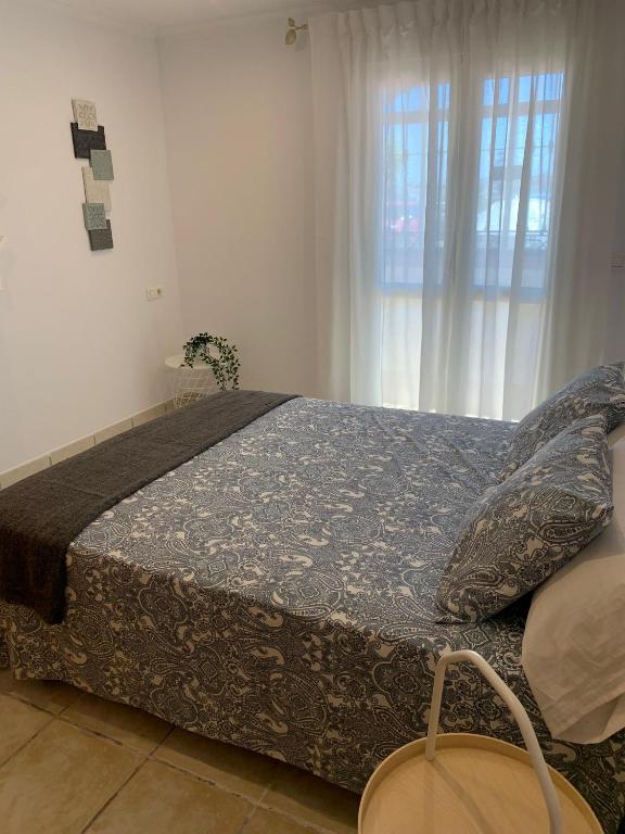 duże łóżko w pokoju z oknem w obiekcie apartamento centrico silencioso w mieście Nerja