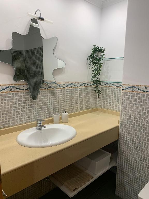 łazienka z umywalką i lustrem w obiekcie apartamento centrico silencioso w mieście Nerja
