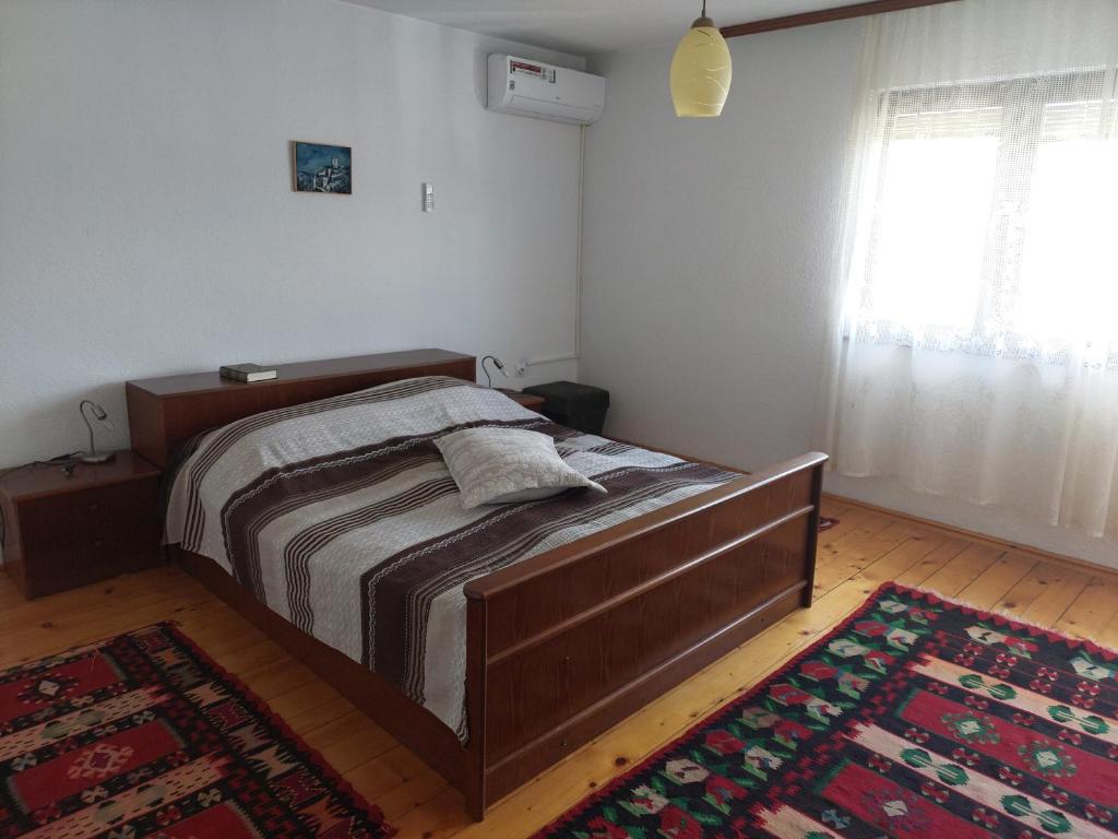a bedroom with a large wooden bed with a rug at Holiday Home Nana in Bugojno