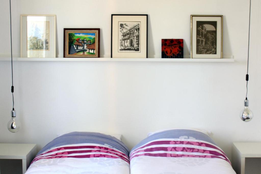 1 dormitorio con 2 almohadas y estante con fotografías en World House Wetten, en Kevelaer