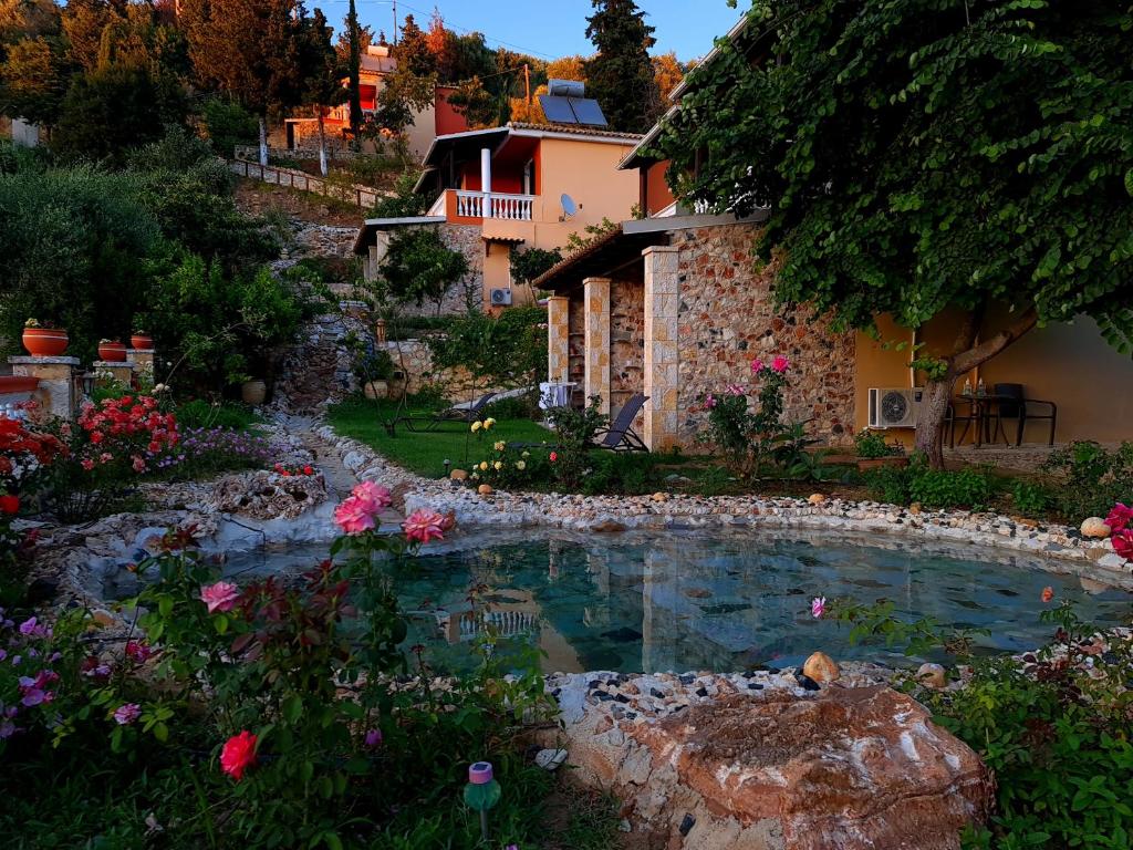 a swimming pool in a garden next to a house at Edem Studios in Syvota