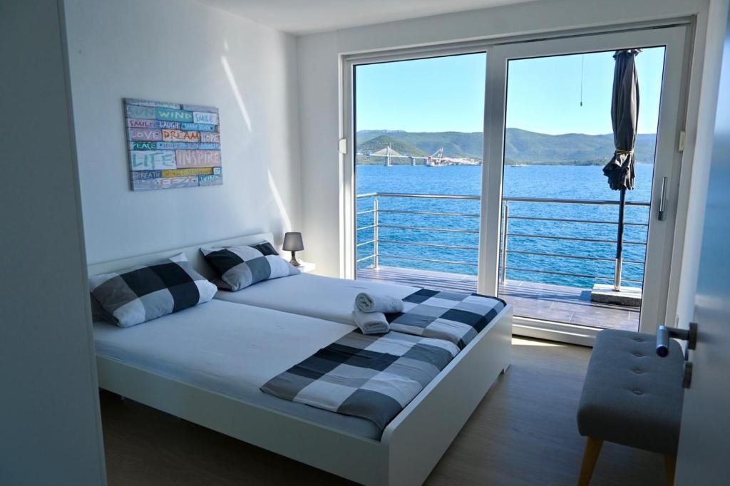 a bedroom with a bed with a view of the water at Apartment First Row in Komarna